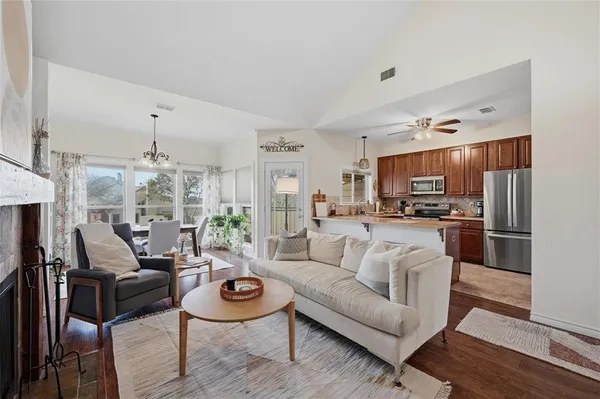 a living room with furniture kitchen view and a chandelier