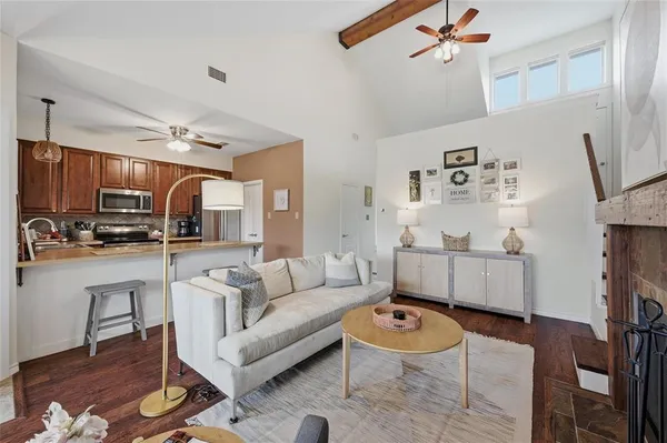 a living room with furniture a flat screen tv and kitchen view