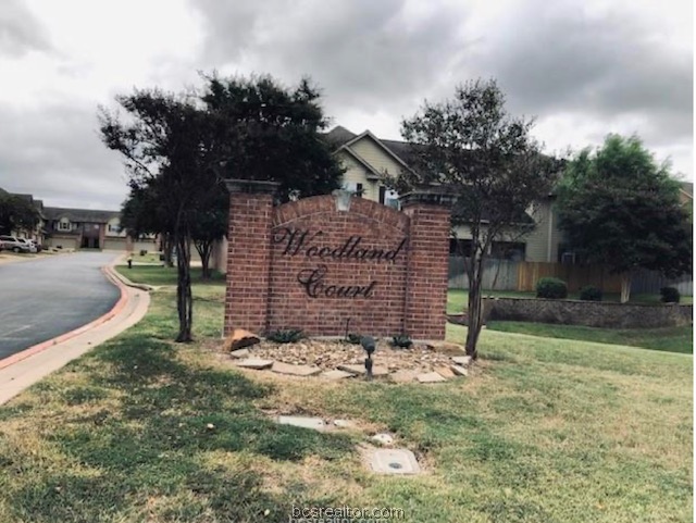 1425 West Villa Maria Road Bryan, TX 77801 - Photo 19 of 19 Brick monument sign with stone accents, landscaping, and a manicured lawn