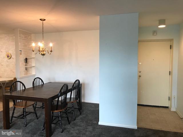 130 Slade Avenue, Unit 411 Baltimore, MD 21208 - Photo 5 of 18 a view of a dining room with furniture and chandelier