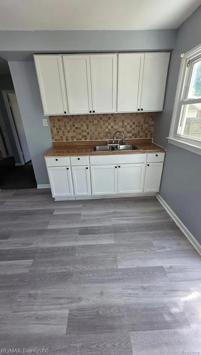 6646 Harding Street Taylor, MI 48180 - Photo 9 of 9 Kitchenette featuring white cabinetry, a dual basin stainless steel sink, a mosaic tile backsplash, and wood-finish countertops
