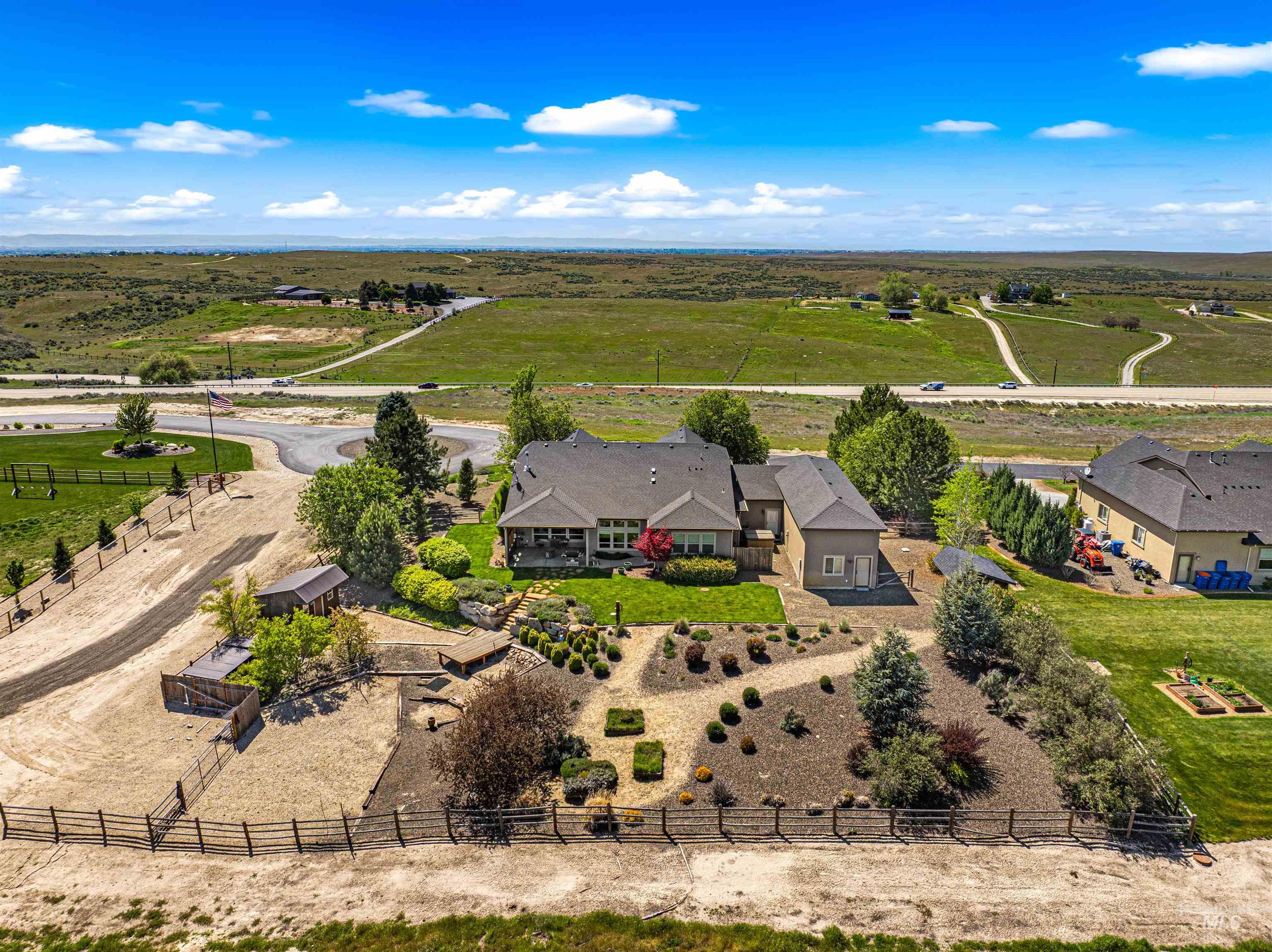 7521 North Grand Ridge Lane Eagle, ID 83616 - Photo 5 of 50 Expansive property featuring a large residence with a covered patio, a manicured lawn, and structured landscaping