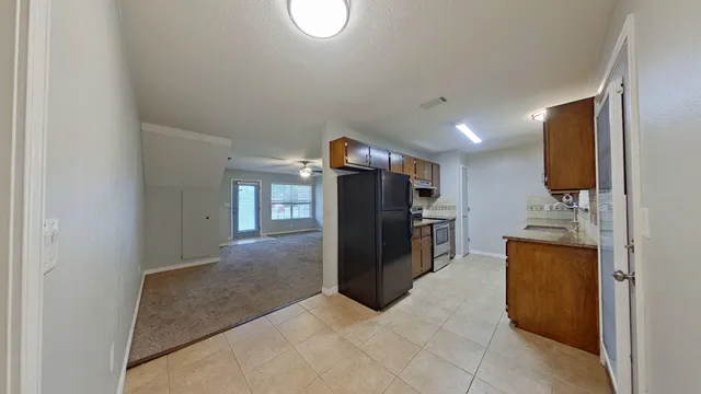 a view of a kitchen with fridge and workspace