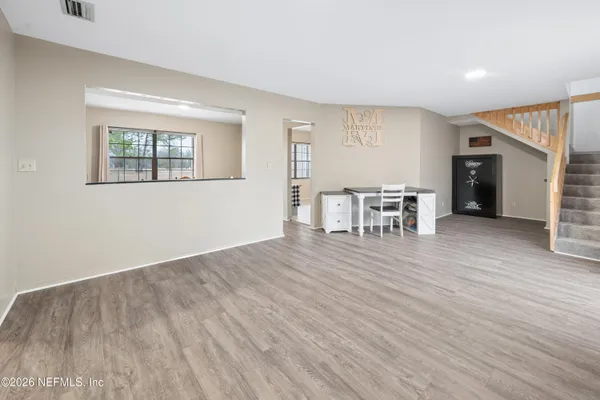 an empty room with wooden floor and windows
