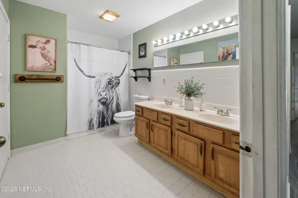 a bathroom with a double vanity sink a mirror and a shower