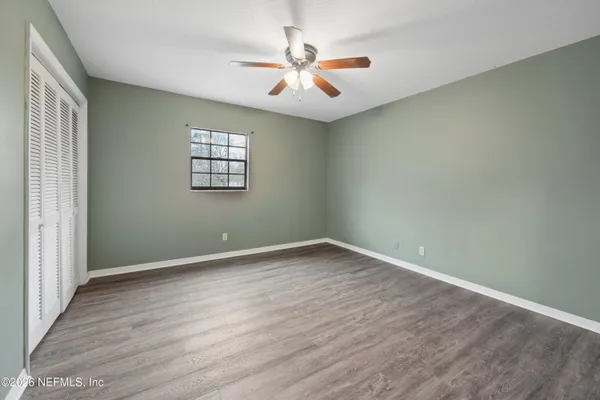 an empty room with wooden floor and windows