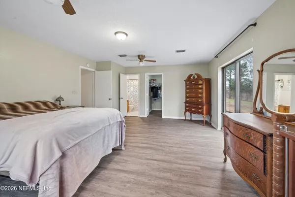 a spacious bedroom with a bed and a dresser