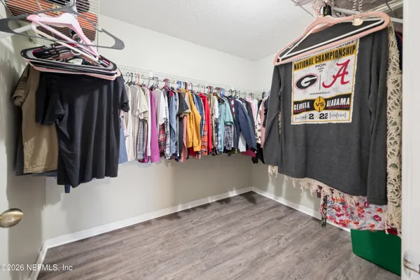 a view of walk in closet with clothes