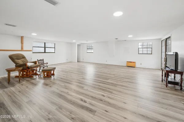 a living room with furniture and a wooden floor