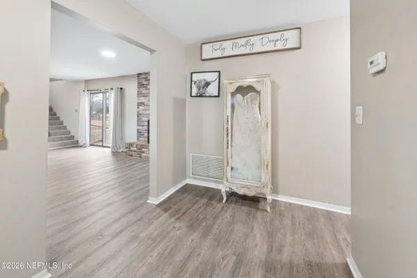 a view of empty room with wooden floor