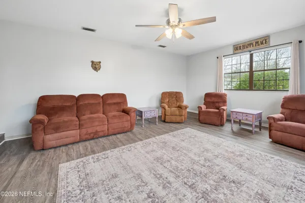 a living room with furniture ceiling fan and a window