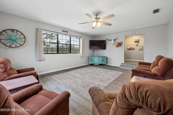 a living room with furniture ceiling fan and a window