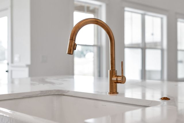 a kitchen with stainless steel appliances granite countertop a sink a stove and a wooden floors