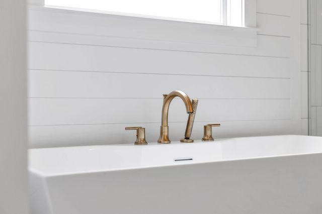 a spacious bathroom with a tub sink double and mirror