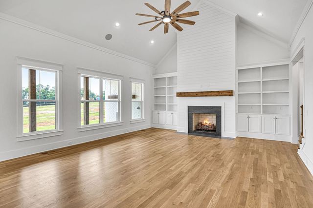 a view of an empty room with a fireplace and a window