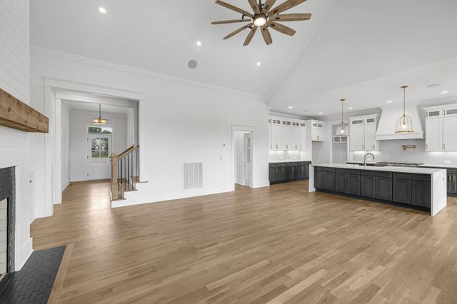 a large kitchen with stainless steel appliances granite countertop a sink a stove and a wooden floors