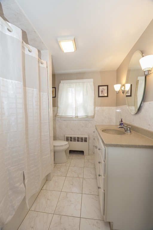 85 Russ Street Randolph, MA 02368 - Photo 10 of 16 a bathroom with a granite countertop sink a toilet and a mirror