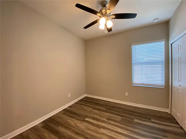an empty room with a window and a fan