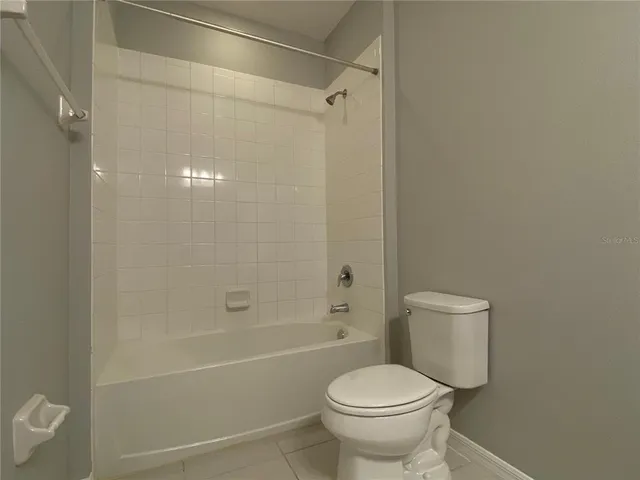 a white toilet sitting next to a bath tub and a shower