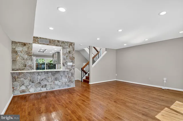 a bedroom with a bed lamp and wooden floor