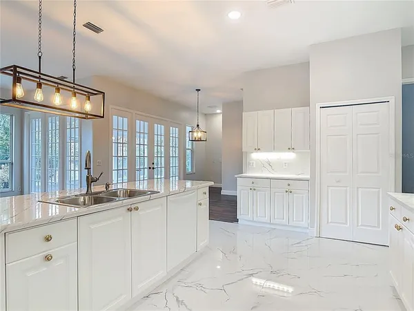 a large kitchen with kitchen island a sink and wooden floor