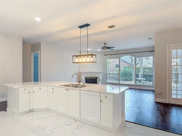 a view of empty room with wooden floor fan and fireplace