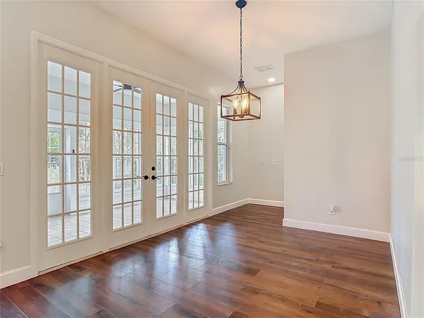 a view of an empty room with wooden floor
