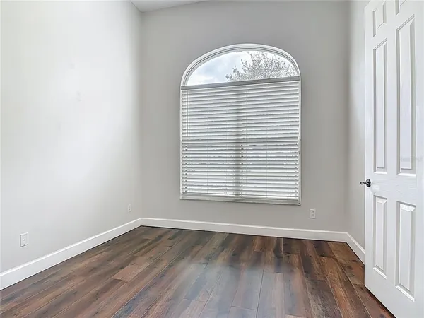 an empty room with wooden floor and a window