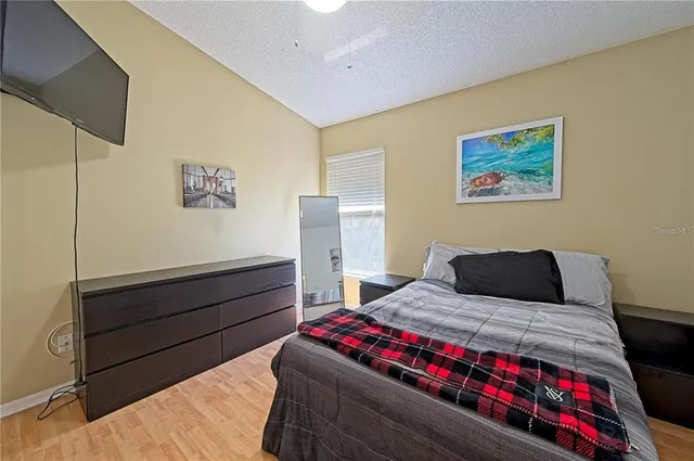 a bedroom with a bed and a painting on the wall