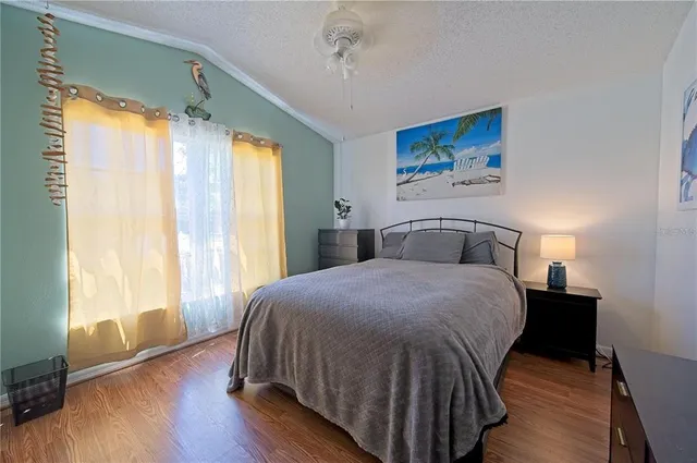 a bedroom with a bed and wooden floor