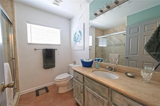 a bathroom with a granite countertop sink mirror vanity and toilet
