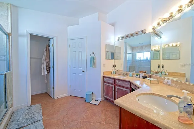 a spacious bathroom with a sink double vanity granite tub shower and a mirror