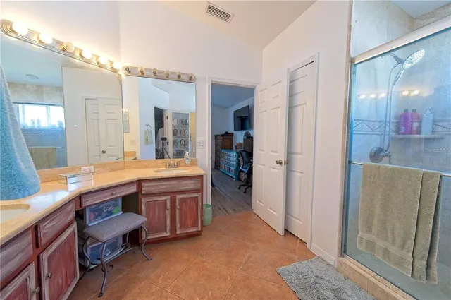 a spacious bathroom with a granite countertop sink and a mirror