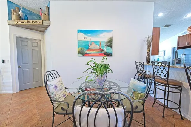 a view of a dining room with furniture one side kitchen view and wooden floor