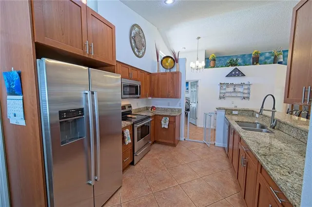a kitchen with stainless steel appliances granite countertop a refrigerator and a stove top oven