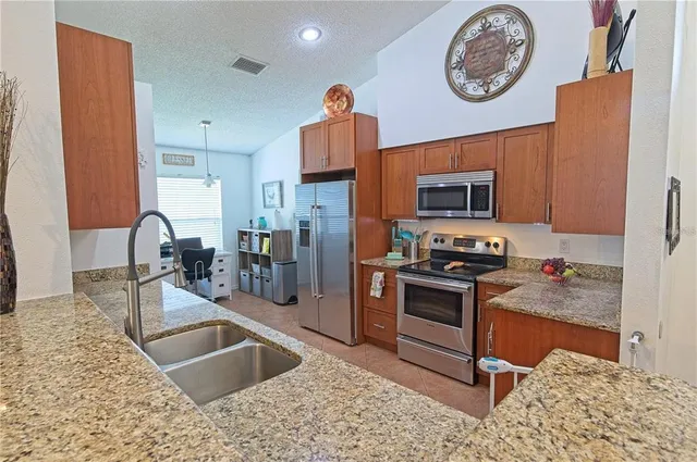 a kitchen with stainless steel appliances granite countertop a sink stove and refrigerator