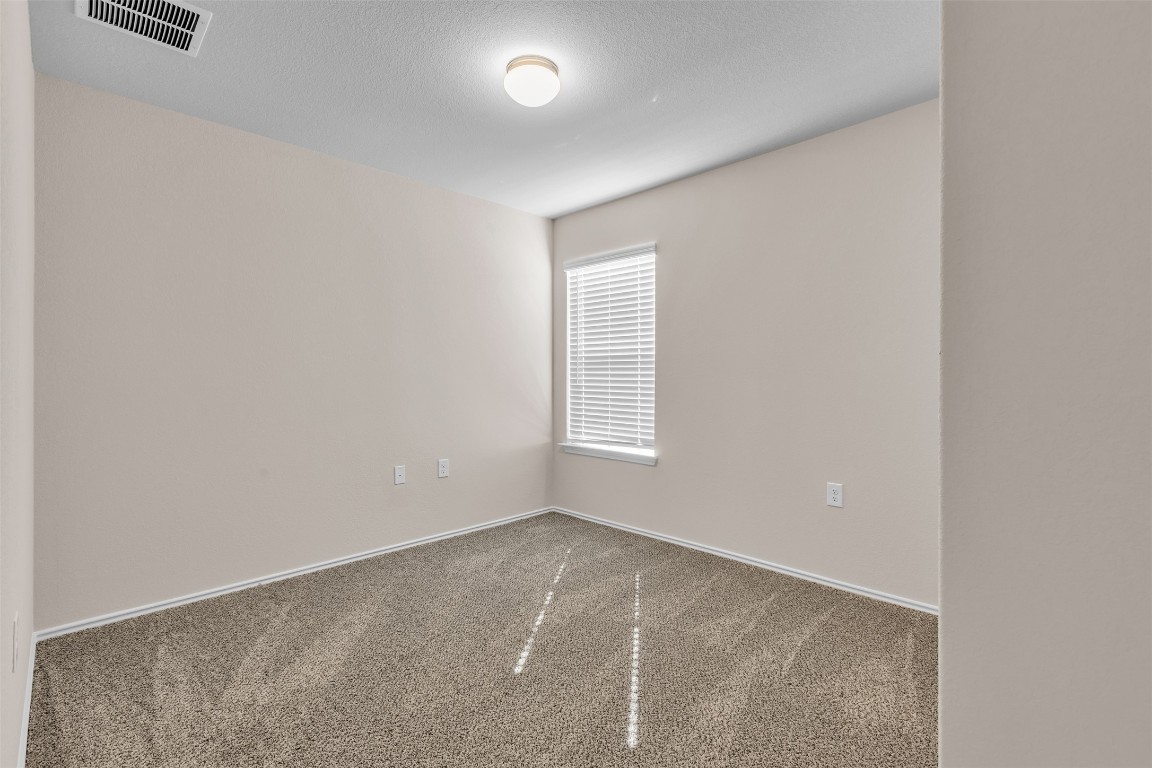 9200 Furman Drive Austin, TX 78747 - Photo 11 of 15 Empty room with carpet floors and a textured ceiling