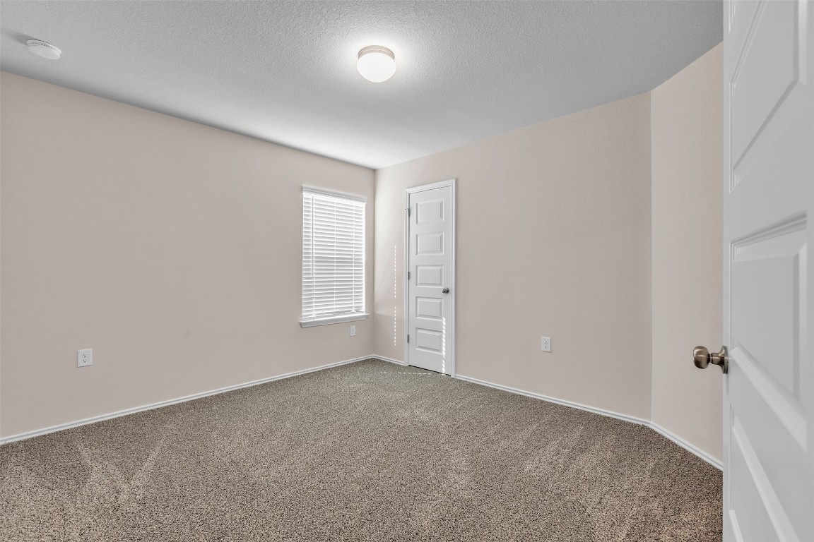 9200 Furman Drive Austin, TX 78747 - Photo 12 of 15 Unfurnished room with carpet and a textured ceiling