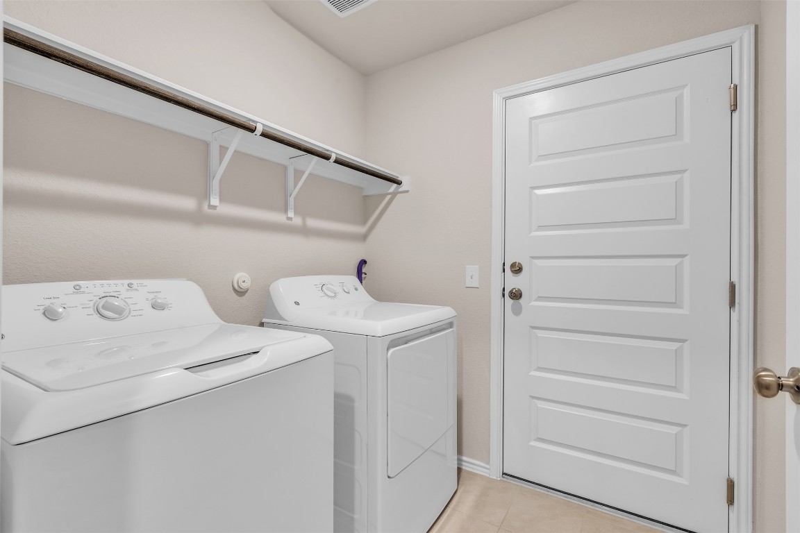 9200 Furman Drive Austin, TX 78747 - Photo 8 of 15 Laundry area with washer and clothes dryer and light tile patterned flooring