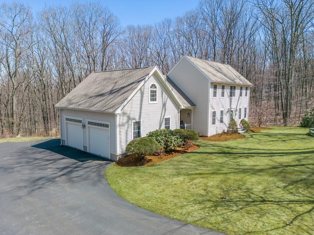 91 Hartness Road Sutton, MA 01590 - Photo 2 of 27 a front view of house with yard and trees in the background