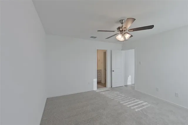 an empty room with a window and a fan