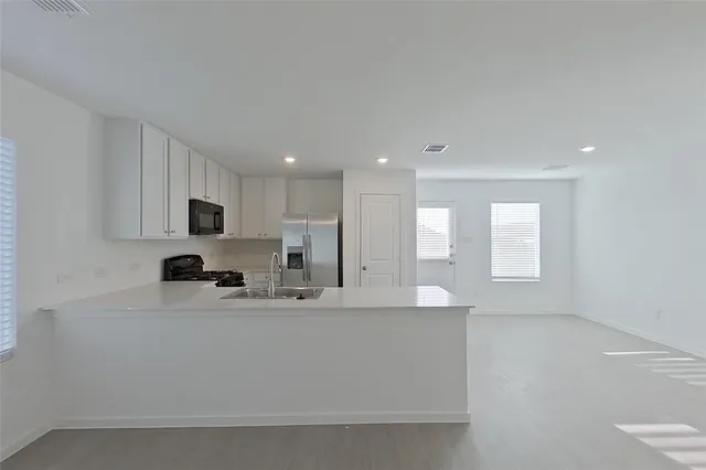 a kitchen with refrigerator and cabinets