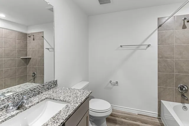 a bathroom with a granite countertop sink toilet and shower