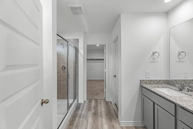a bathroom with a granite countertop shower sink and vanity