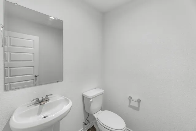 a bathroom with a sink a toilet and mirror