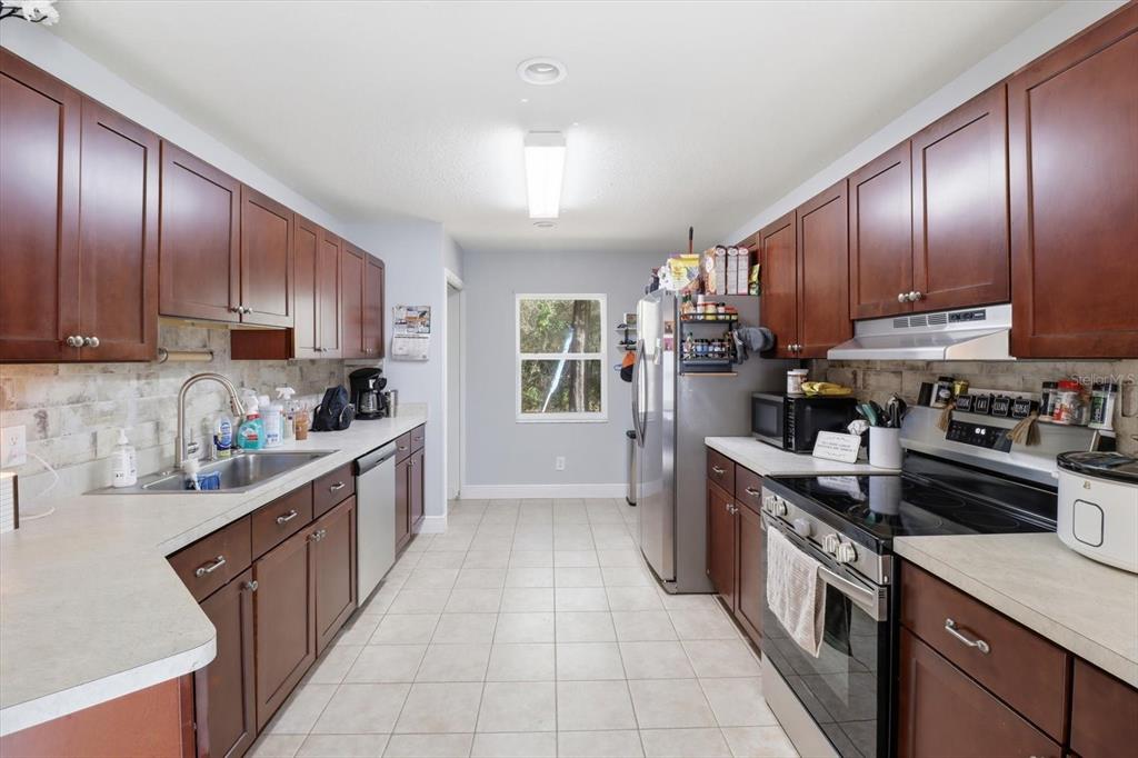 786 North Dugan Avenue Inverness, FL 34453 - Photo 16 of 44 a kitchen with stainless steel appliances granite countertop wooden cabinets a stove top oven a sink and dishwasher