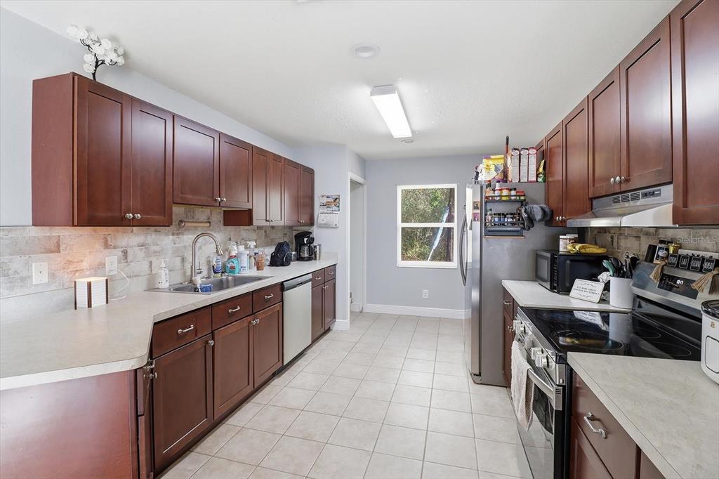 786 North Dugan Avenue Inverness, FL 34453 - Photo 17 of 44 a kitchen with stainless steel appliances granite countertop wooden cabinets a stove top oven a sink and dishwasher