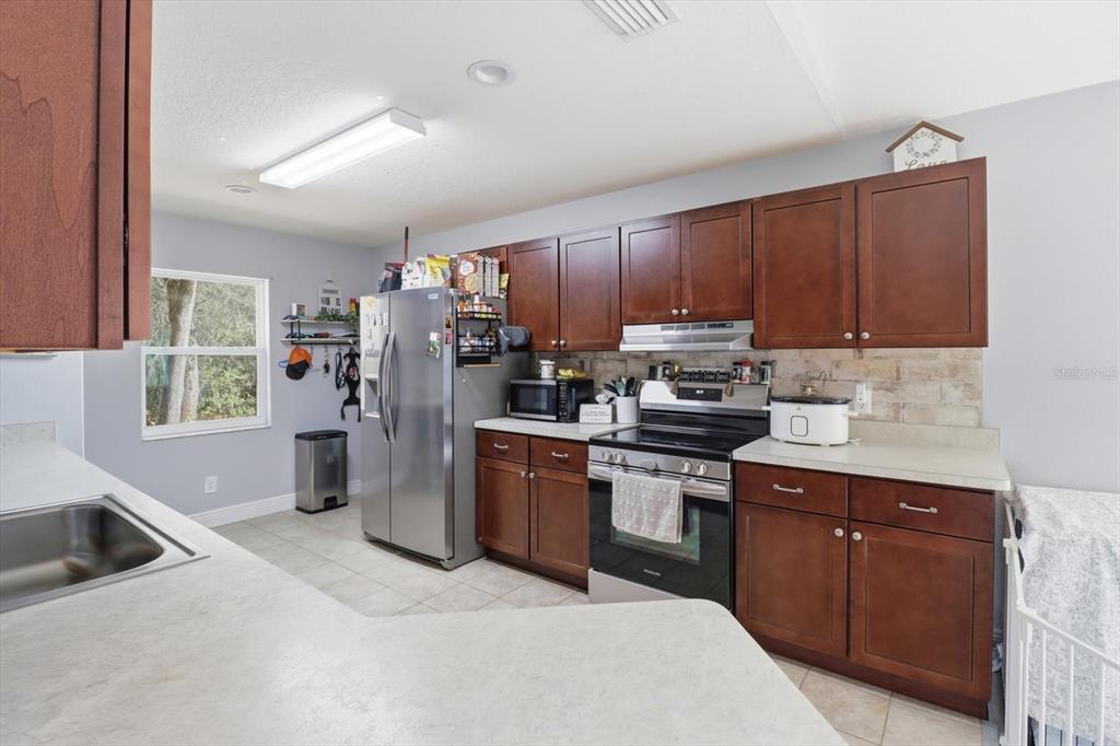 786 North Dugan Avenue Inverness, FL 34453 - Photo 18 of 44 a kitchen with stainless steel appliances granite countertop a refrigerator stove and sink