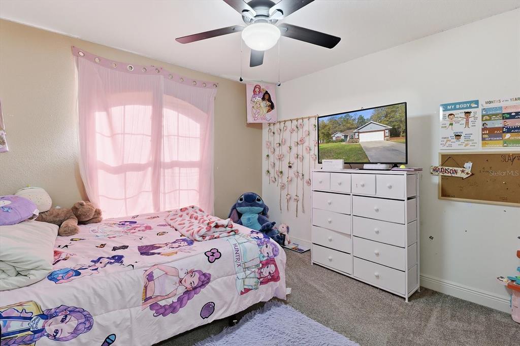786 North Dugan Avenue Inverness, FL 34453 - Photo 24 of 44 a bedroom with a bed and a flat tv screen on dresser