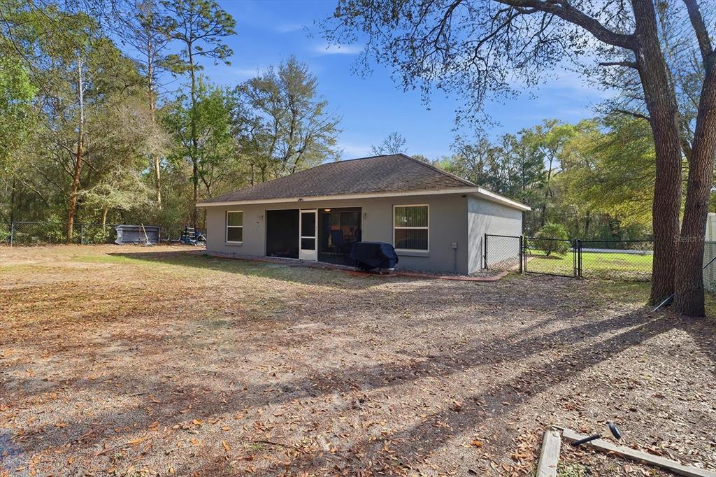 786 North Dugan Avenue Inverness, FL 34453 - Photo 39 of 44 a front view of a house with a garden and trees